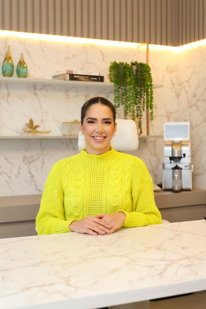 Dra. Júlia Calixto sorrindo em seu consultório